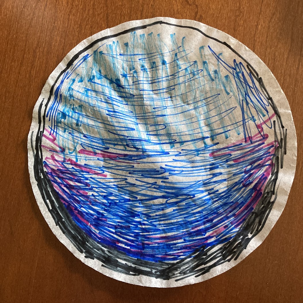 A coffee filter with a sketchy black circle drawn around the outside that is thicker on the bottom than the top and a blue ombre pattern on the bottom half and blue sketchy marker on top.