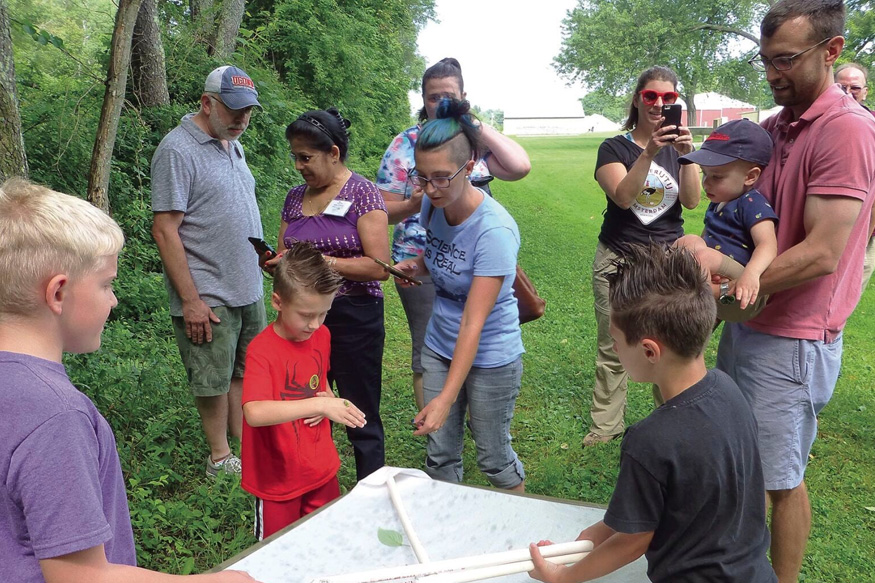 group of kids and adults putting together a kite