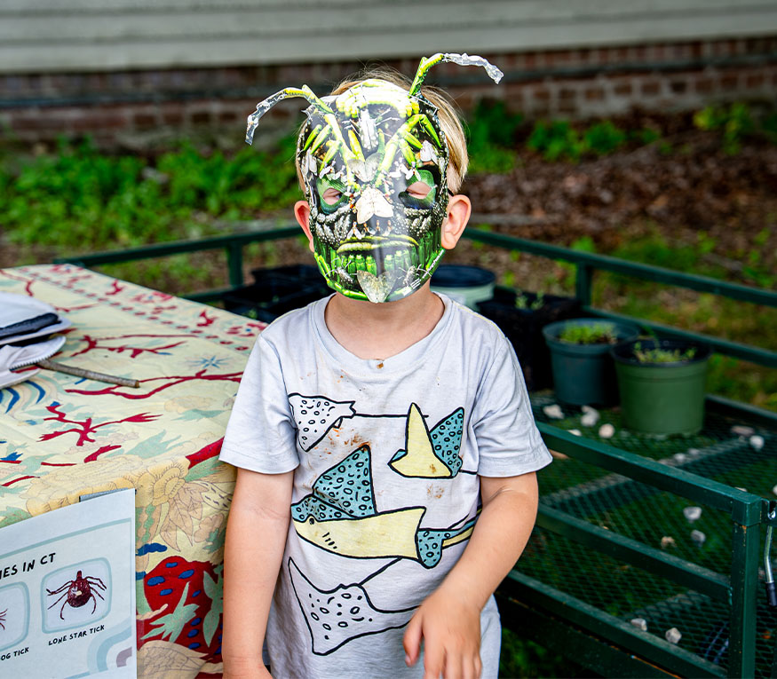 A young boy with a bug mask on.