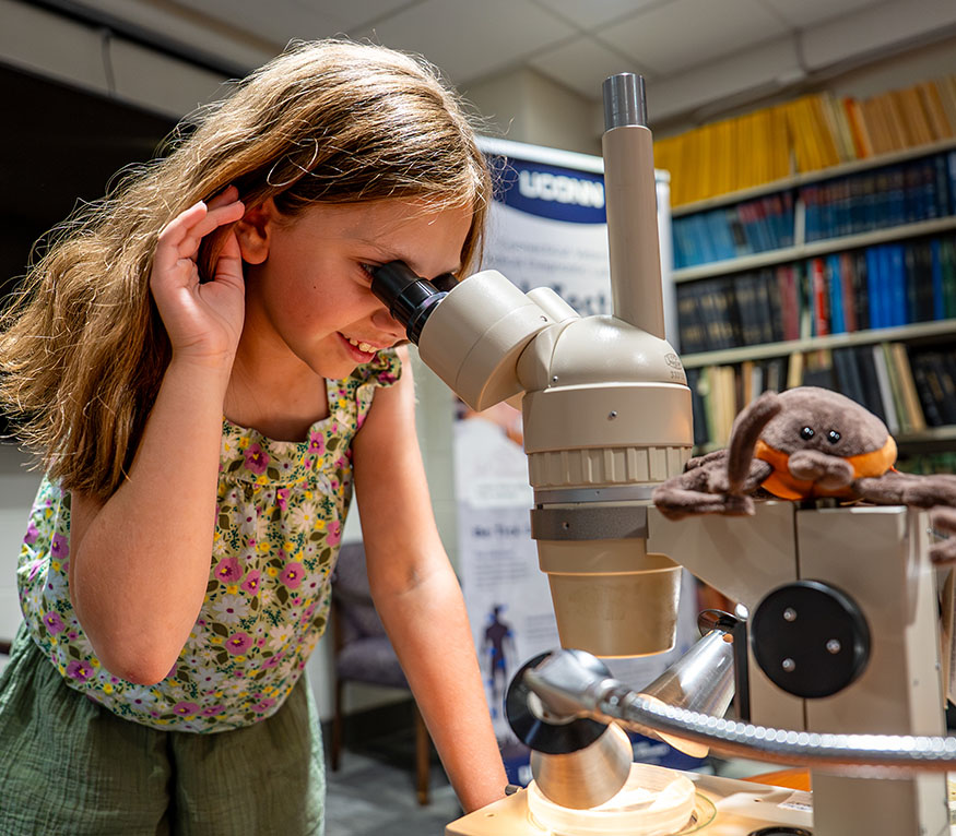A kid looking through a microscope